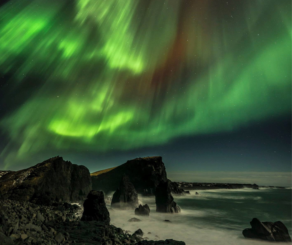 a scene showing the edge of a coast line in the northern lights 